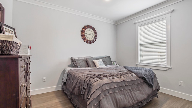 bedroom with ornamental molding and hardwood / wood-style floors