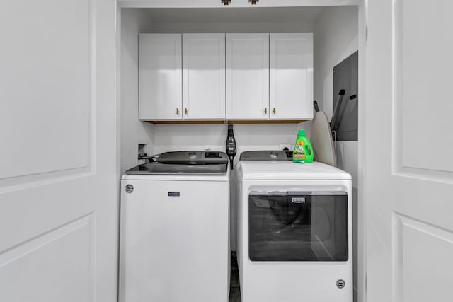 washroom featuring cabinets, electric panel, and washing machine and dryer