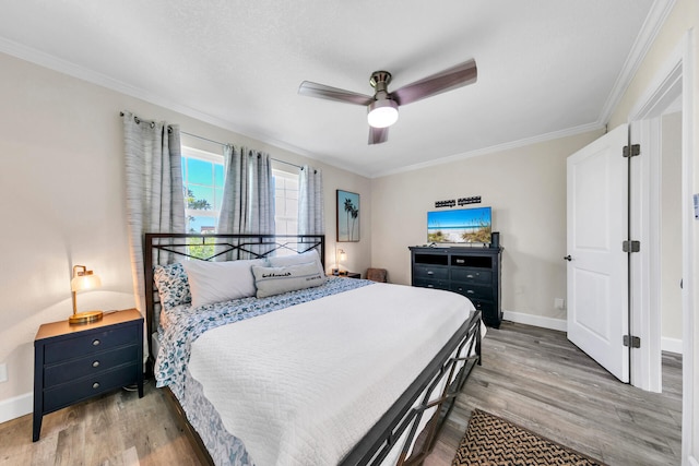 bedroom with ornamental molding, ceiling fan, and light hardwood / wood-style flooring