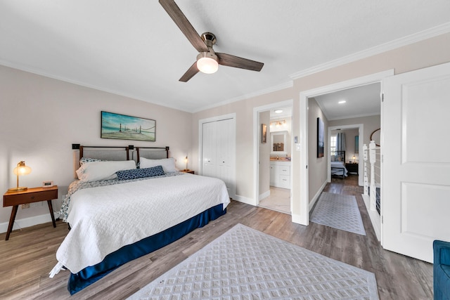 bedroom featuring a closet, crown molding, ceiling fan, hardwood / wood-style floors, and ensuite bath