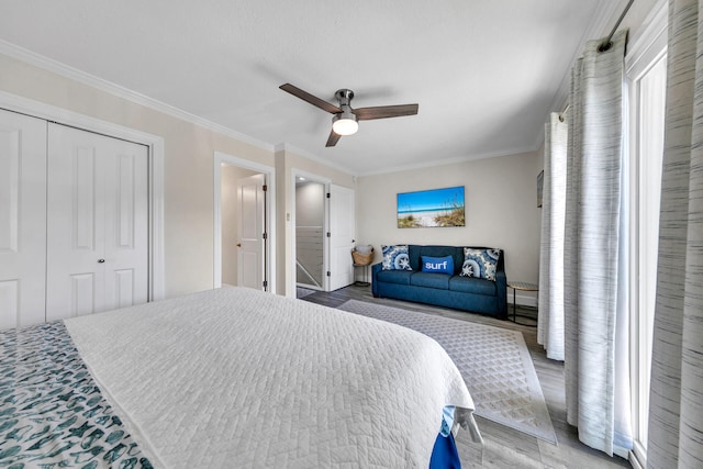 bedroom with a closet, ceiling fan, wood-type flooring, and crown molding