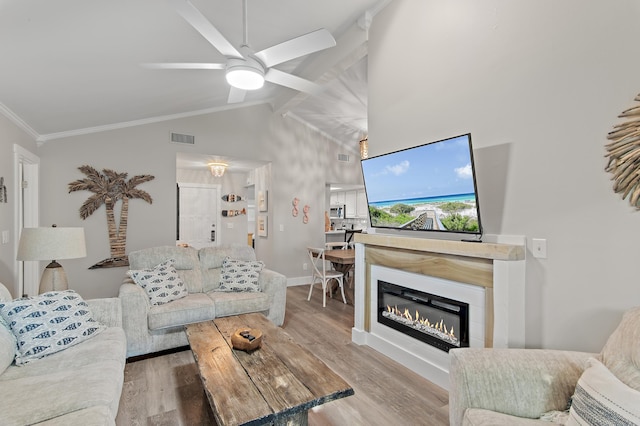 living room with light hardwood / wood-style flooring, ceiling fan, high vaulted ceiling, and crown molding