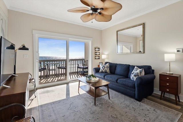 living room with ceiling fan, a water view, light wood-type flooring, and crown molding