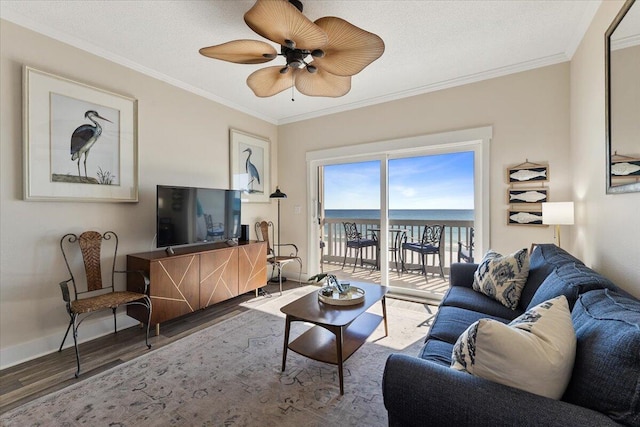 living room with ceiling fan, crown molding, wood-type flooring, and a textured ceiling