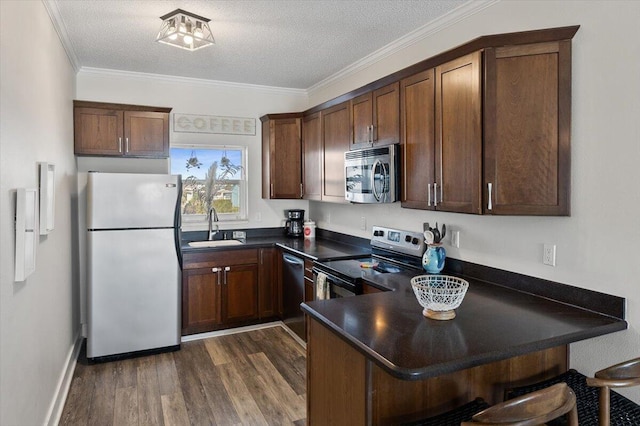 kitchen with dark wood-type flooring, crown molding, sink, a textured ceiling, and stainless steel appliances