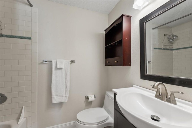 full bathroom featuring vanity, tiled shower / bath, a textured ceiling, and toilet