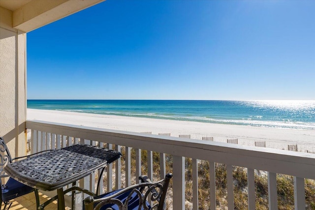 balcony featuring a view of the beach and a water view