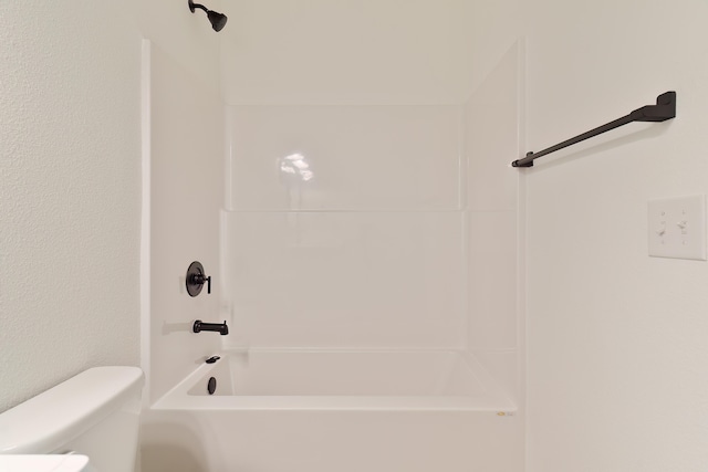 bathroom featuring shower / washtub combination and toilet