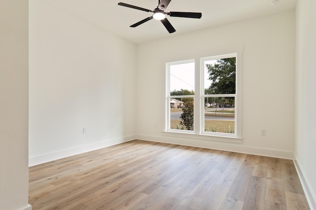 spare room featuring a healthy amount of sunlight, ceiling fan, and light hardwood / wood-style flooring