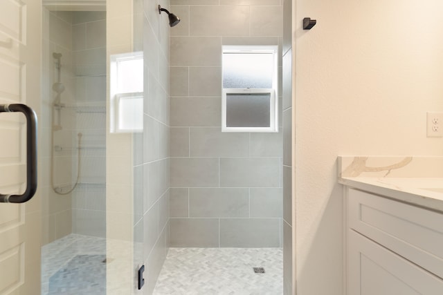 bathroom with vanity and a shower with door