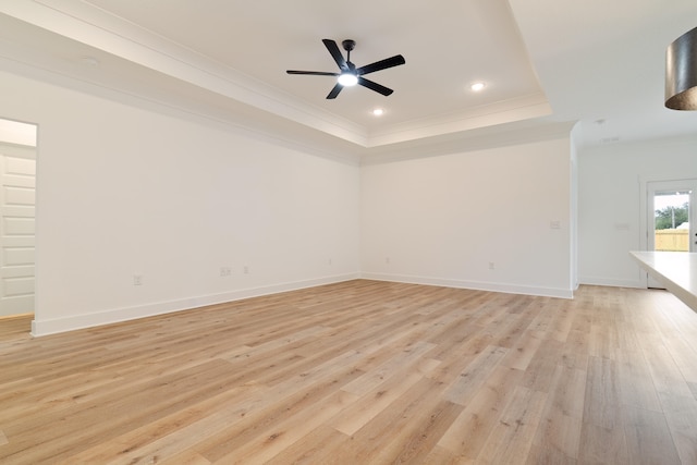 unfurnished living room with crown molding, ceiling fan, a raised ceiling, and light hardwood / wood-style floors