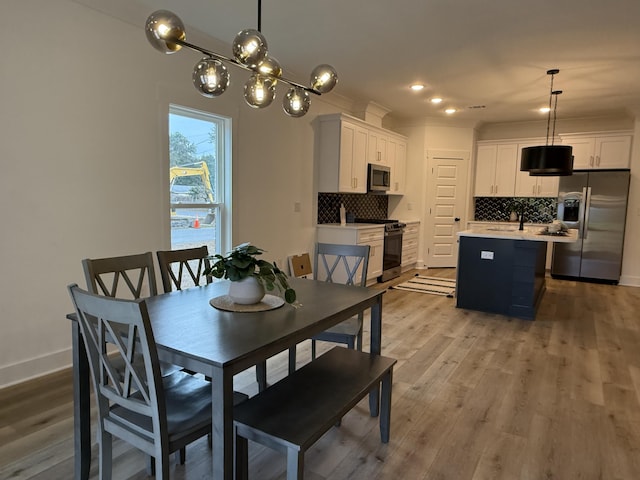 dining space with light hardwood / wood-style flooring and ornamental molding