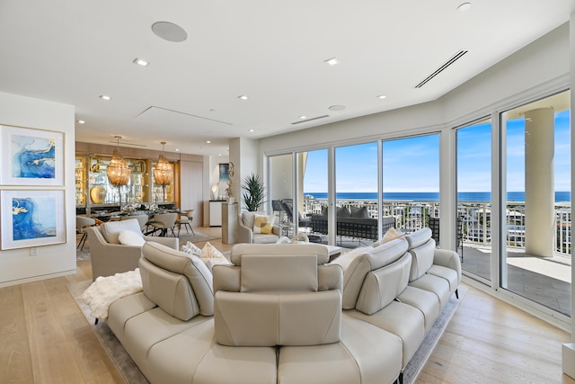 living room featuring light wood-type flooring and a water view