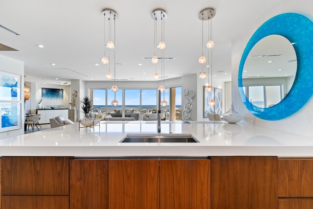 kitchen featuring a kitchen island, decorative light fixtures, and sink