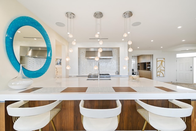 kitchen with wall chimney exhaust hood and decorative light fixtures