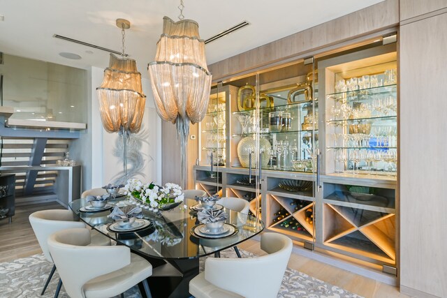 dining space with wood-type flooring and bar