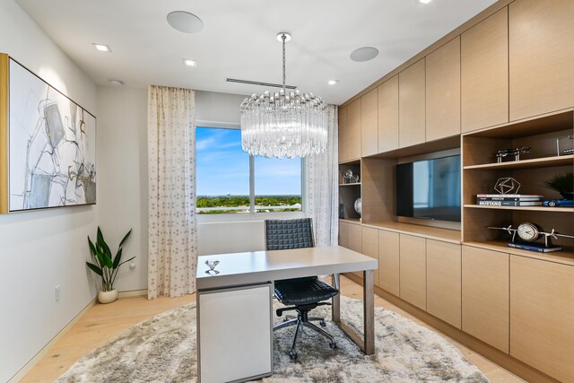 office space featuring an inviting chandelier and light hardwood / wood-style floors