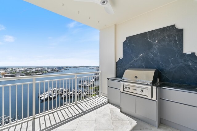 balcony with an outdoor kitchen, a water view, and a grill