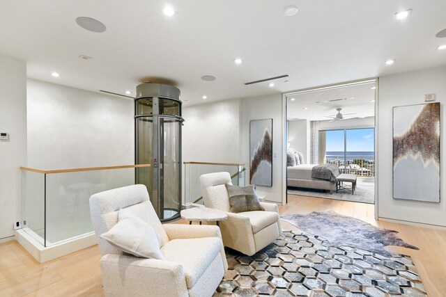 sitting room with ceiling fan and light hardwood / wood-style floors