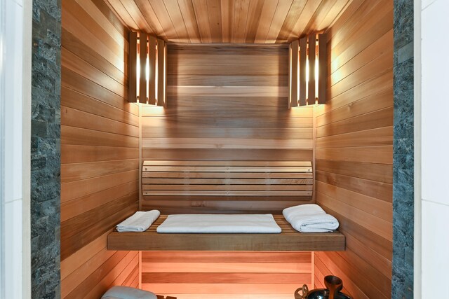 view of sauna with wood ceiling and wood walls