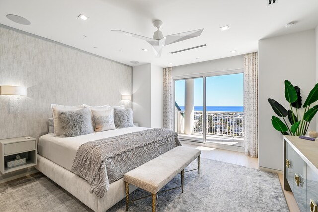 bedroom featuring a water view, ceiling fan, tile patterned floors, and access to exterior