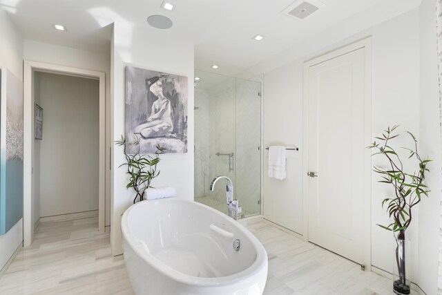 bathroom featuring shower with separate bathtub