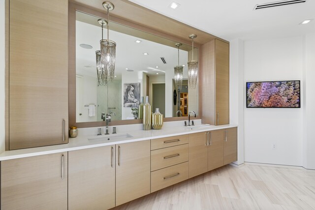 bathroom with wood-type flooring, vanity, and a chandelier