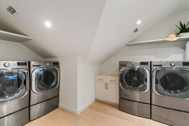 laundry area with light hardwood / wood-style floors and washing machine and clothes dryer