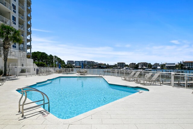 view of pool featuring a patio and a water view