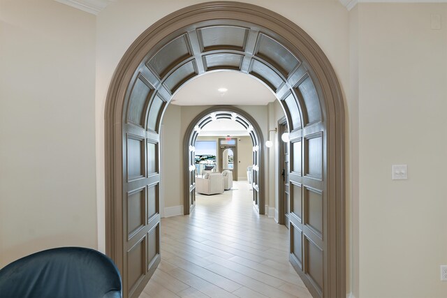 hall featuring ornamental molding and light hardwood / wood-style floors