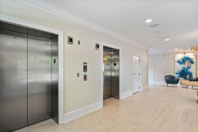 hall featuring light hardwood / wood-style floors, elevator, and crown molding