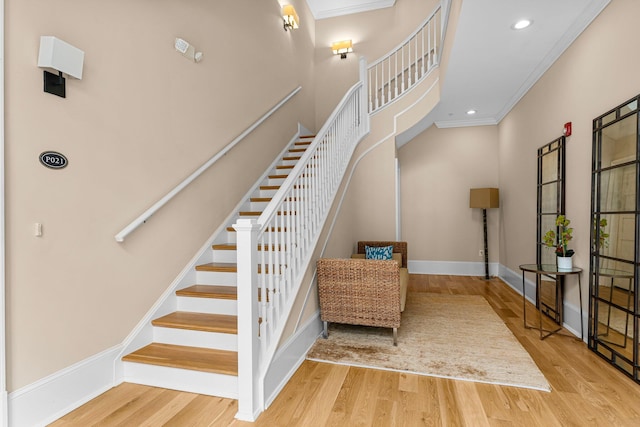 staircase featuring hardwood / wood-style flooring and crown molding