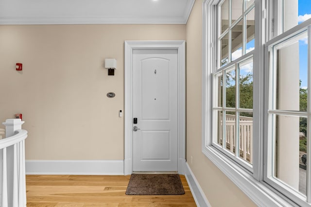 doorway with crown molding and light hardwood / wood-style floors