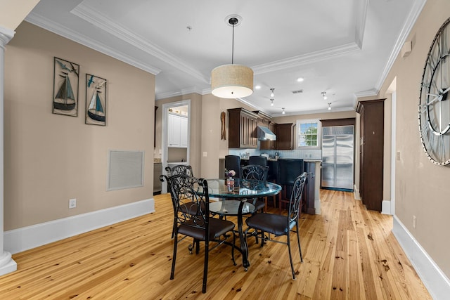 dining area with light hardwood / wood-style floors and crown molding