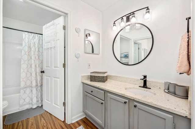 full bathroom with vanity, hardwood / wood-style floors, toilet, and shower / bath combo