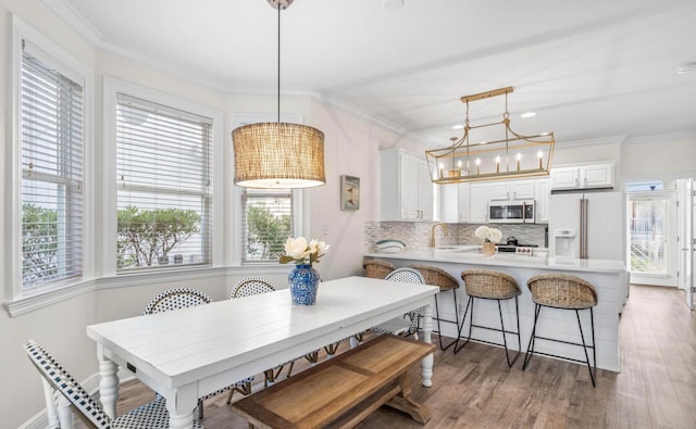 dining space with a chandelier, hardwood / wood-style floors, and crown molding