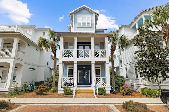 coastal inspired home featuring french doors, a balcony, and central AC