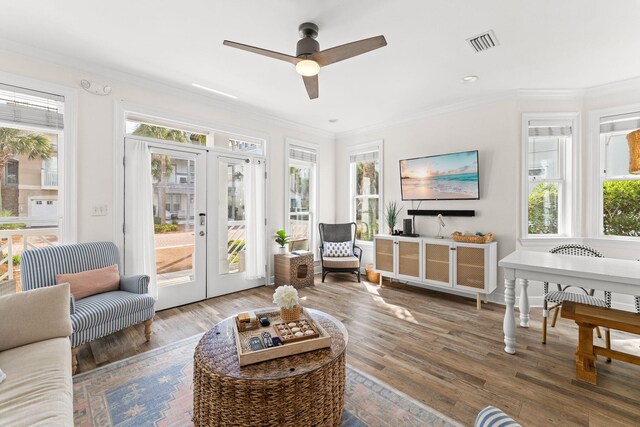 living room with a wealth of natural light, ceiling fan, dark wood-type flooring, and crown molding