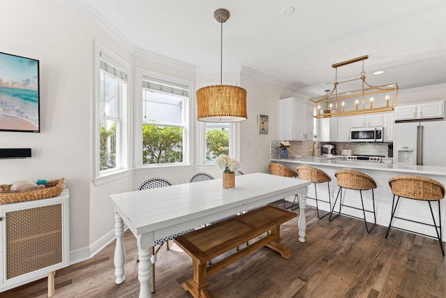 dining area featuring a notable chandelier, sink, dark hardwood / wood-style floors, and crown molding