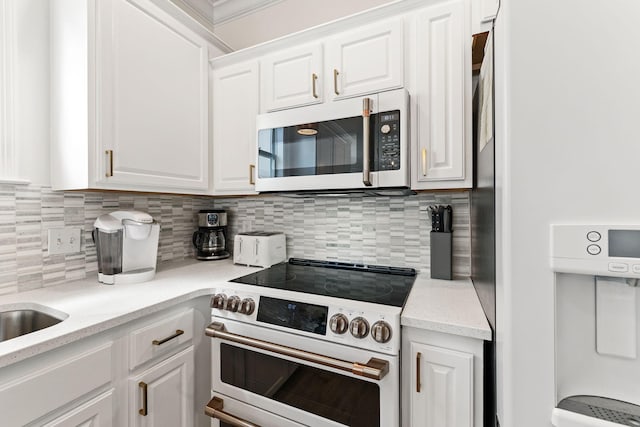 kitchen with stainless steel appliances, backsplash, and white cabinetry