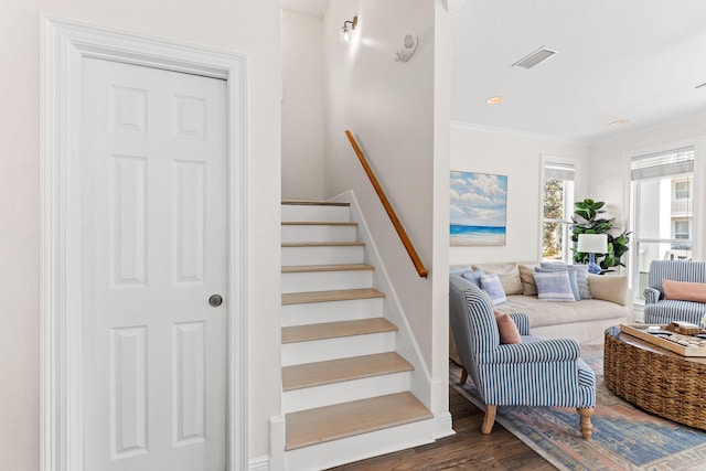 stairs with ornamental molding and hardwood / wood-style floors