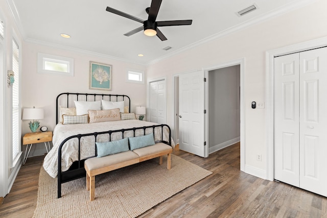 bedroom with ornamental molding, multiple windows, and dark hardwood / wood-style floors