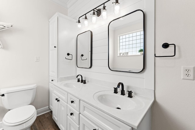 bathroom with wood-type flooring, vanity, toilet, and ornamental molding