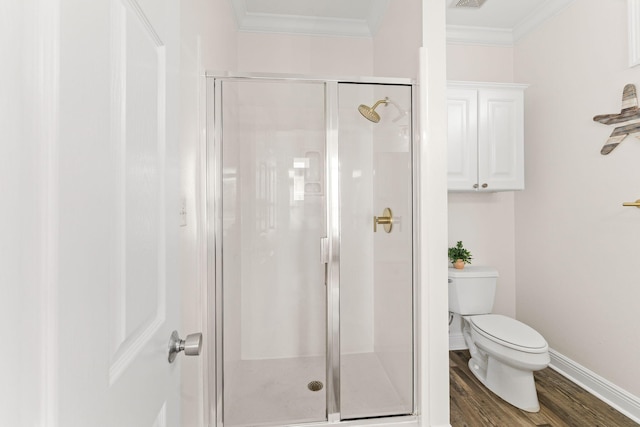 bathroom with crown molding, a shower with door, hardwood / wood-style floors, and toilet