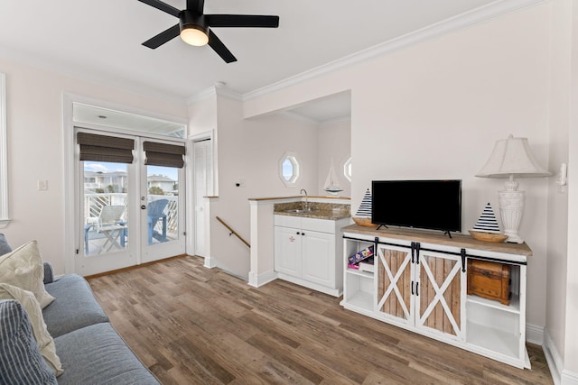 living room with ceiling fan, hardwood / wood-style flooring, crown molding, and sink