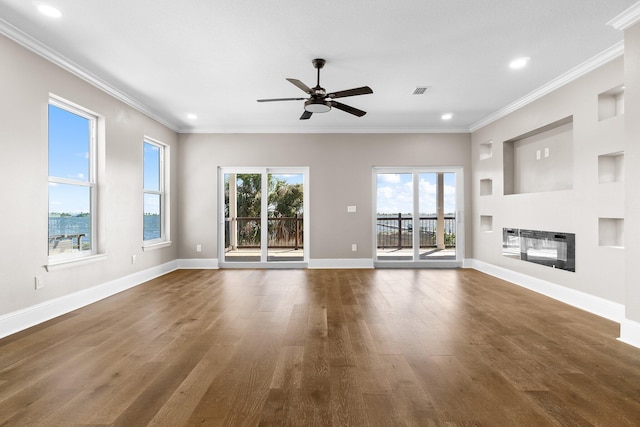 unfurnished living room featuring dark hardwood / wood-style flooring, ornamental molding, and ceiling fan