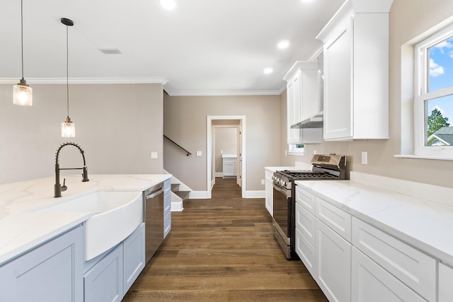 kitchen with appliances with stainless steel finishes, white cabinetry, sink, hanging light fixtures, and light stone counters