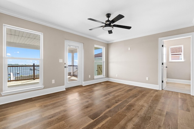 spare room featuring crown molding, dark wood-type flooring, and ceiling fan