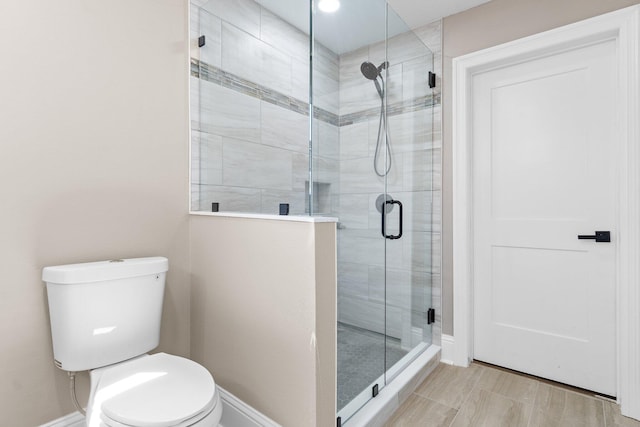 bathroom featuring an enclosed shower and toilet