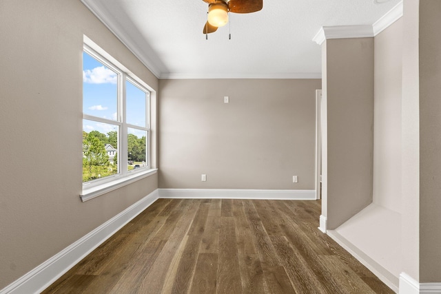 empty room featuring dark wood-type flooring, ceiling fan, and ornamental molding